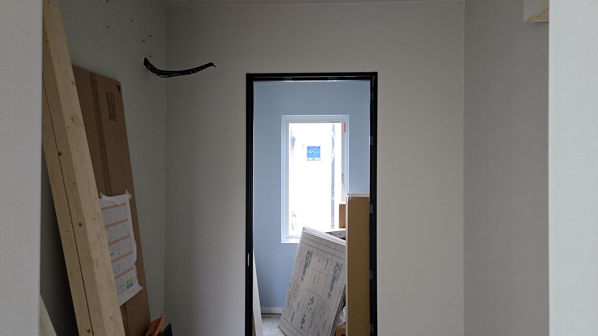 内装業者によるクロス貼りが行われている様子です。養生をきちんとして、汚さないように施工しています。