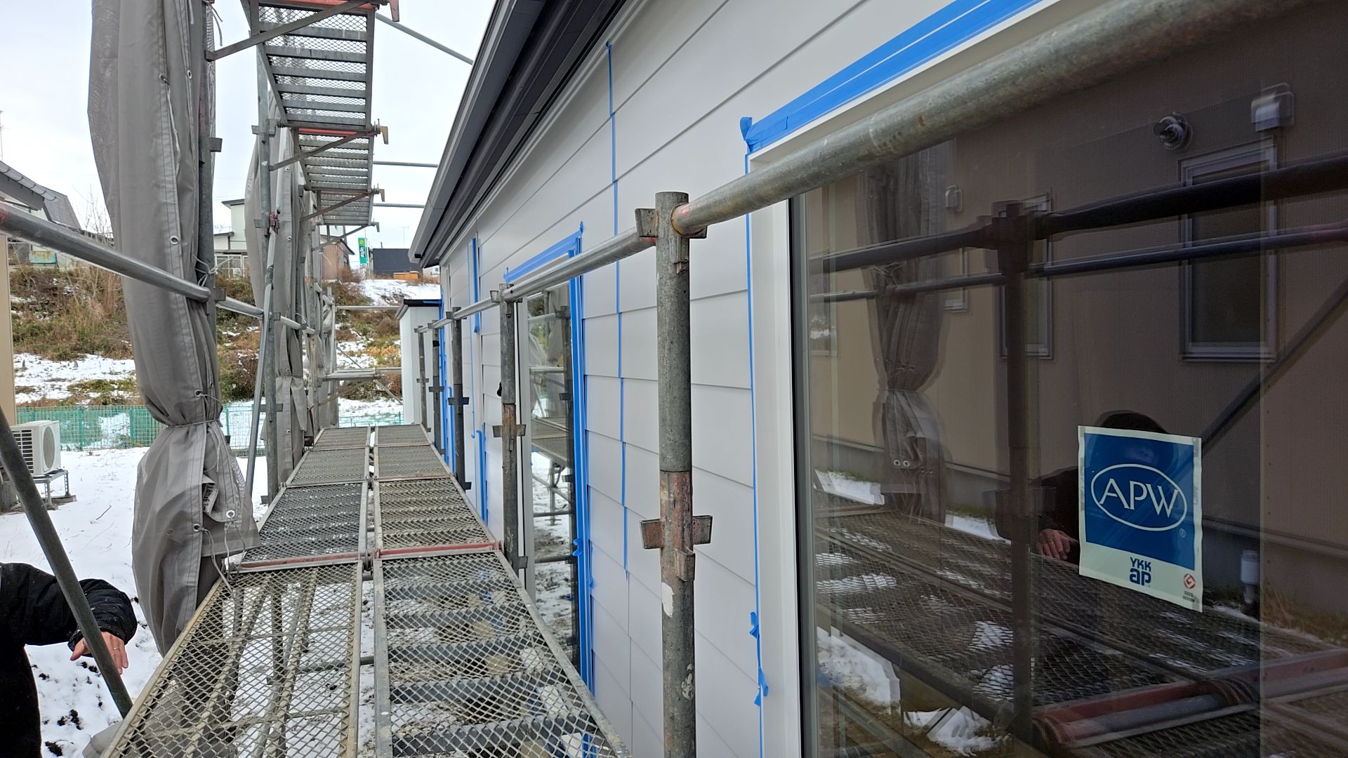 塗装業者によるコーキング工事の様子です。雪で濡れた足場などで転倒しないよう安全には十分注意し、施工しております。