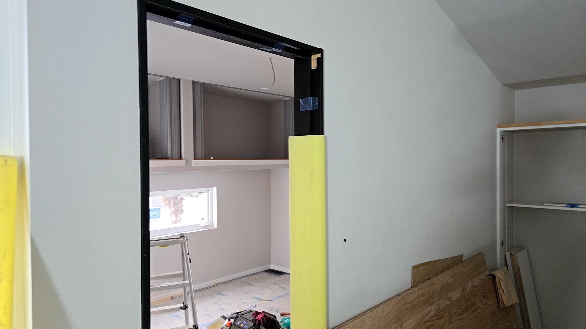 内装業者によるクロス貼りの様子です。ヨレやシワが出ないよう丁寧に作業しています。