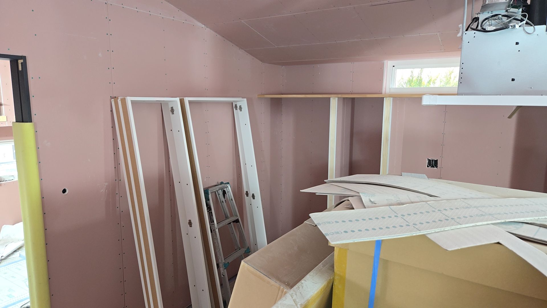 収納部分の造作工事が行われております。収納部分の棚板を取り付ける作業を行っております。