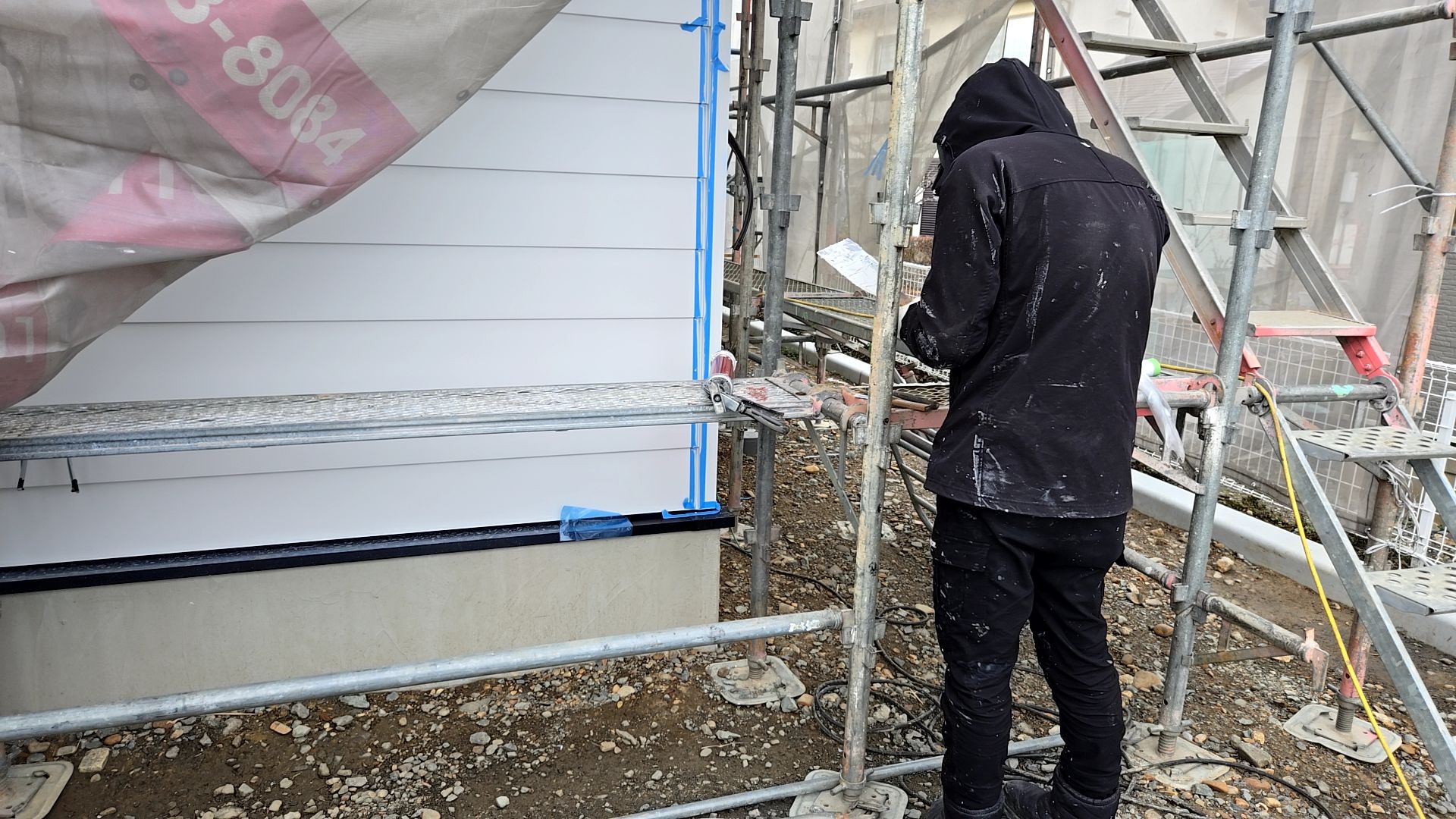 塗装業者によるコーキング工事の様子です。外壁に汚れが付かないようマスキングテープでしっかりと養生しております。