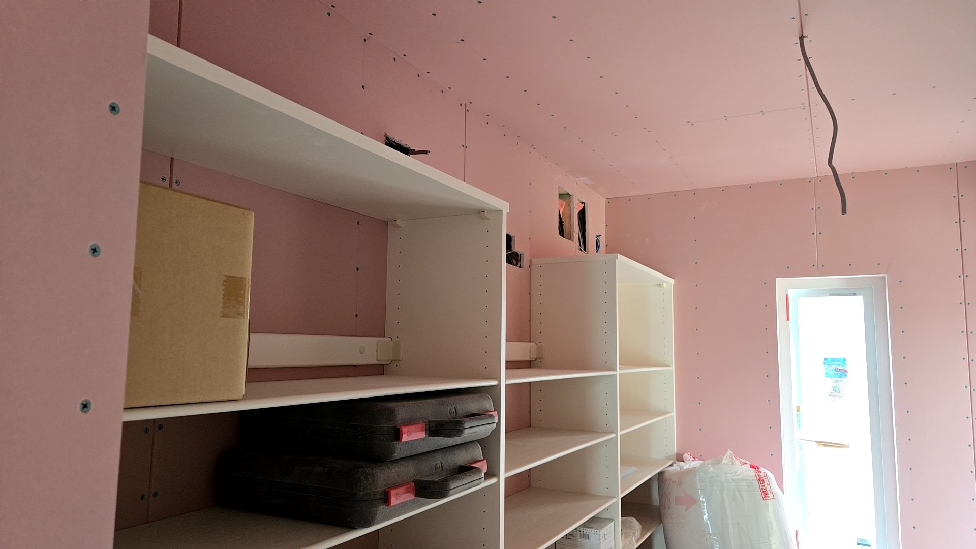 収納棚の造作工事が行われております。図面・仕様を確認し正確に取り付けています。