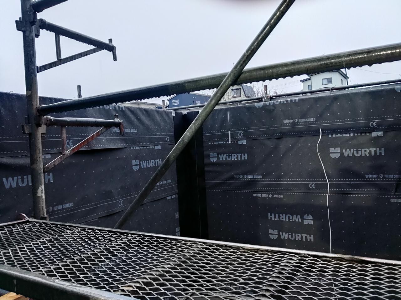 外部の防水紙貼りが行われている様子です。シワやヨレができないよう、また重なりの部分に注意して丁寧に貼っていきます。