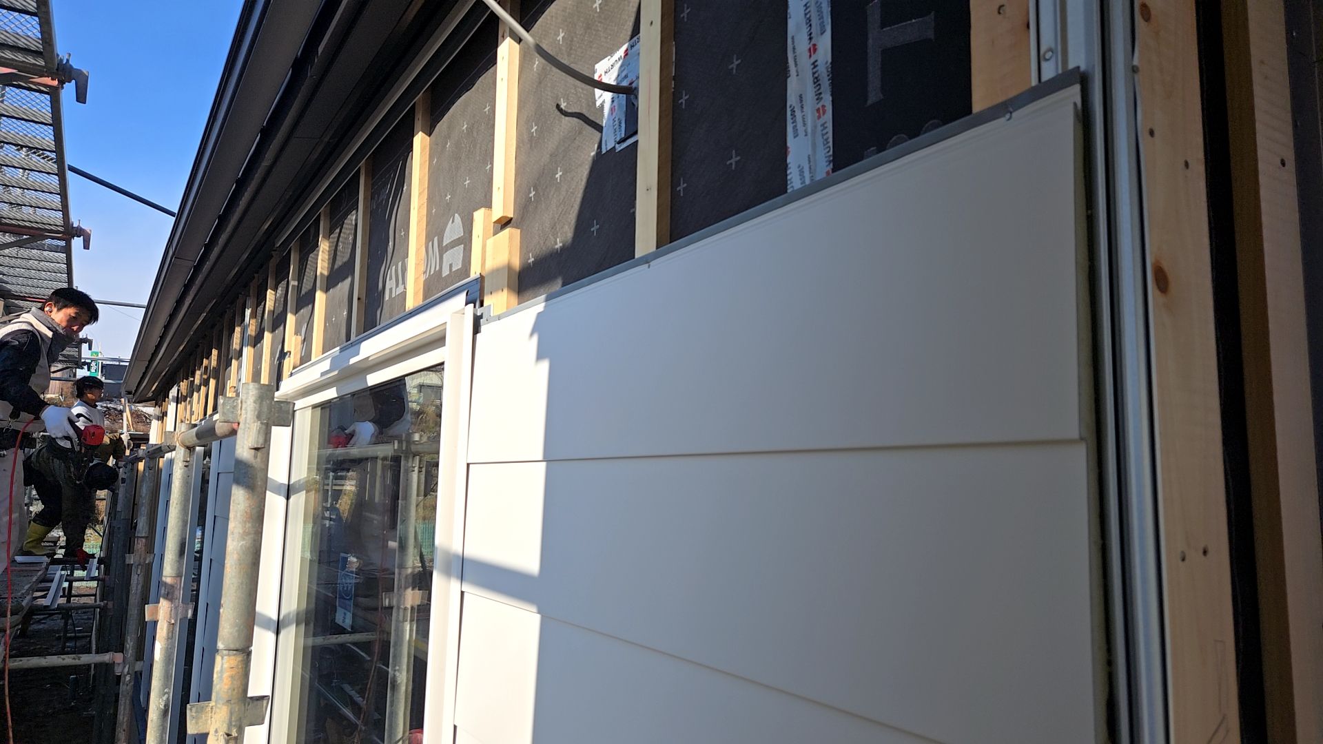 外壁貼りの様子です。キズや汚れが付かないよう十分に注意しながら作業を進めています。