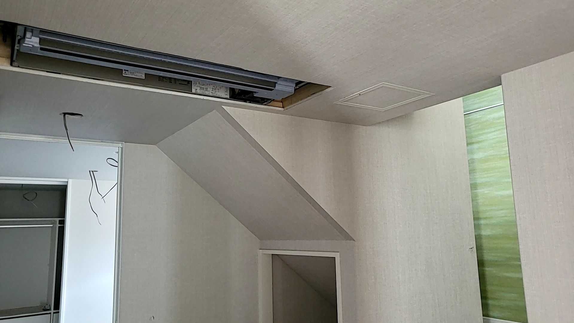 内装業者によるクロス貼りの様子です。