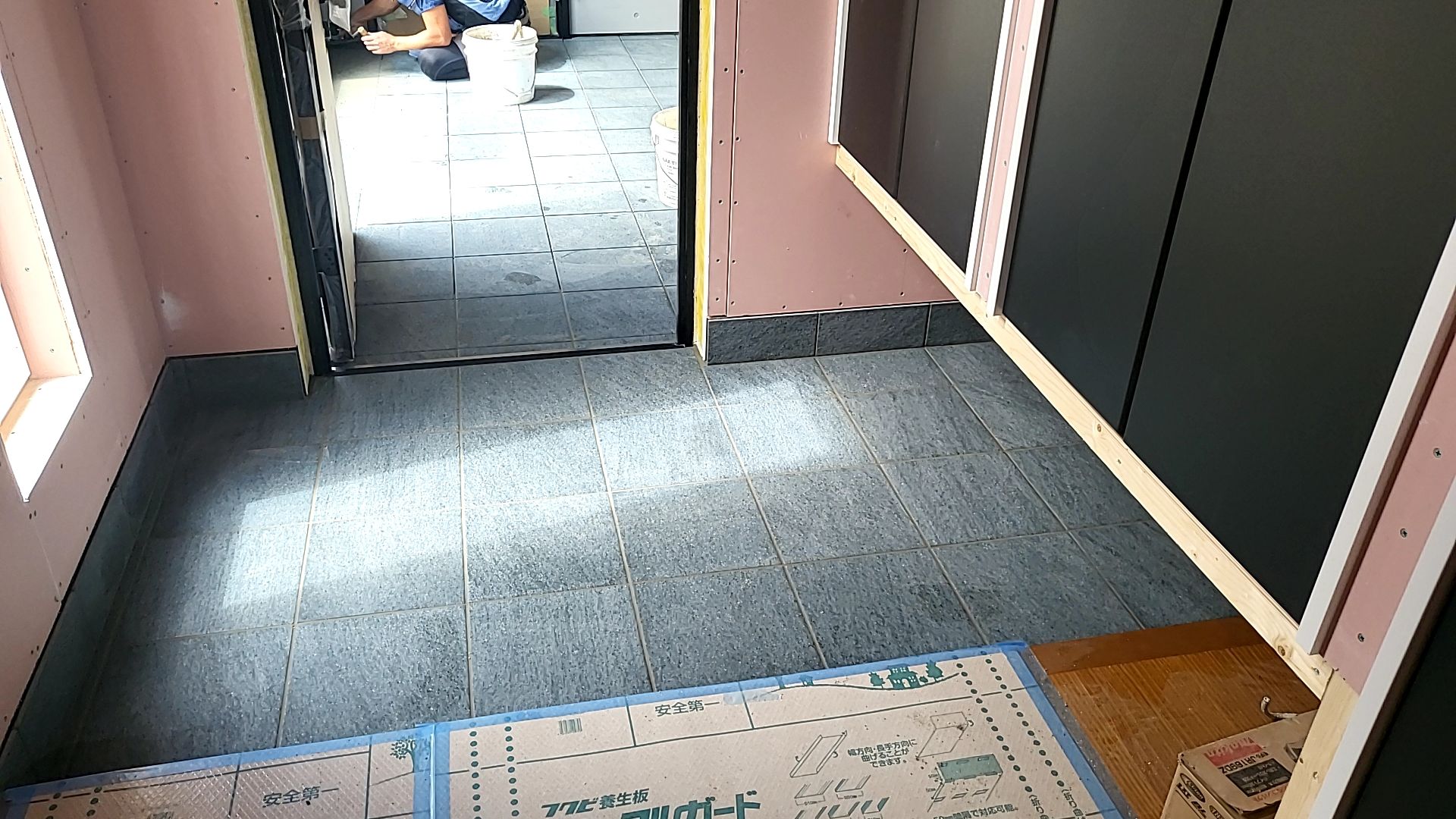 玄関のタイル貼りが終わり、タイルの目地詰めを行っている様子です。