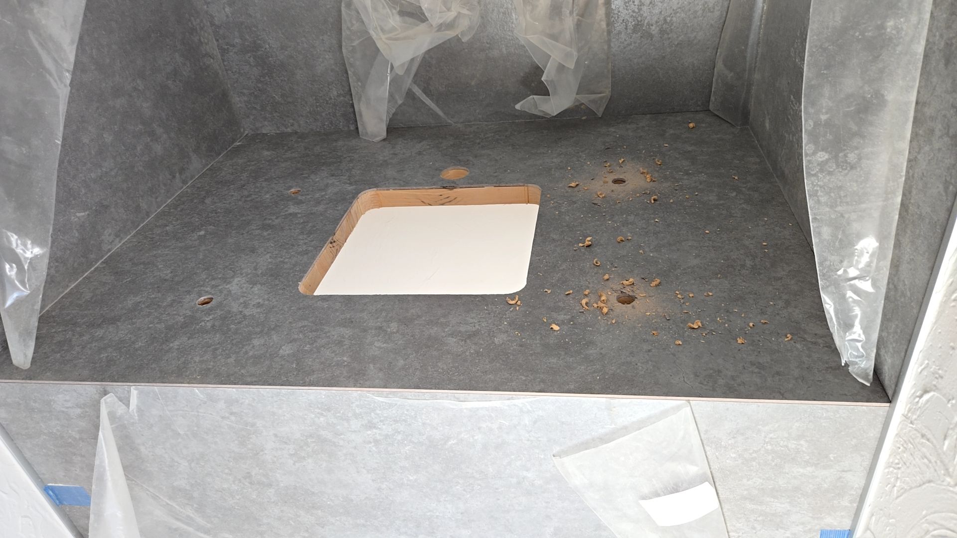 手洗い器機の取り付けのため、カウンターに穴をあけている様子です。周りにキズを付けないよう丁寧に施工を行っております。