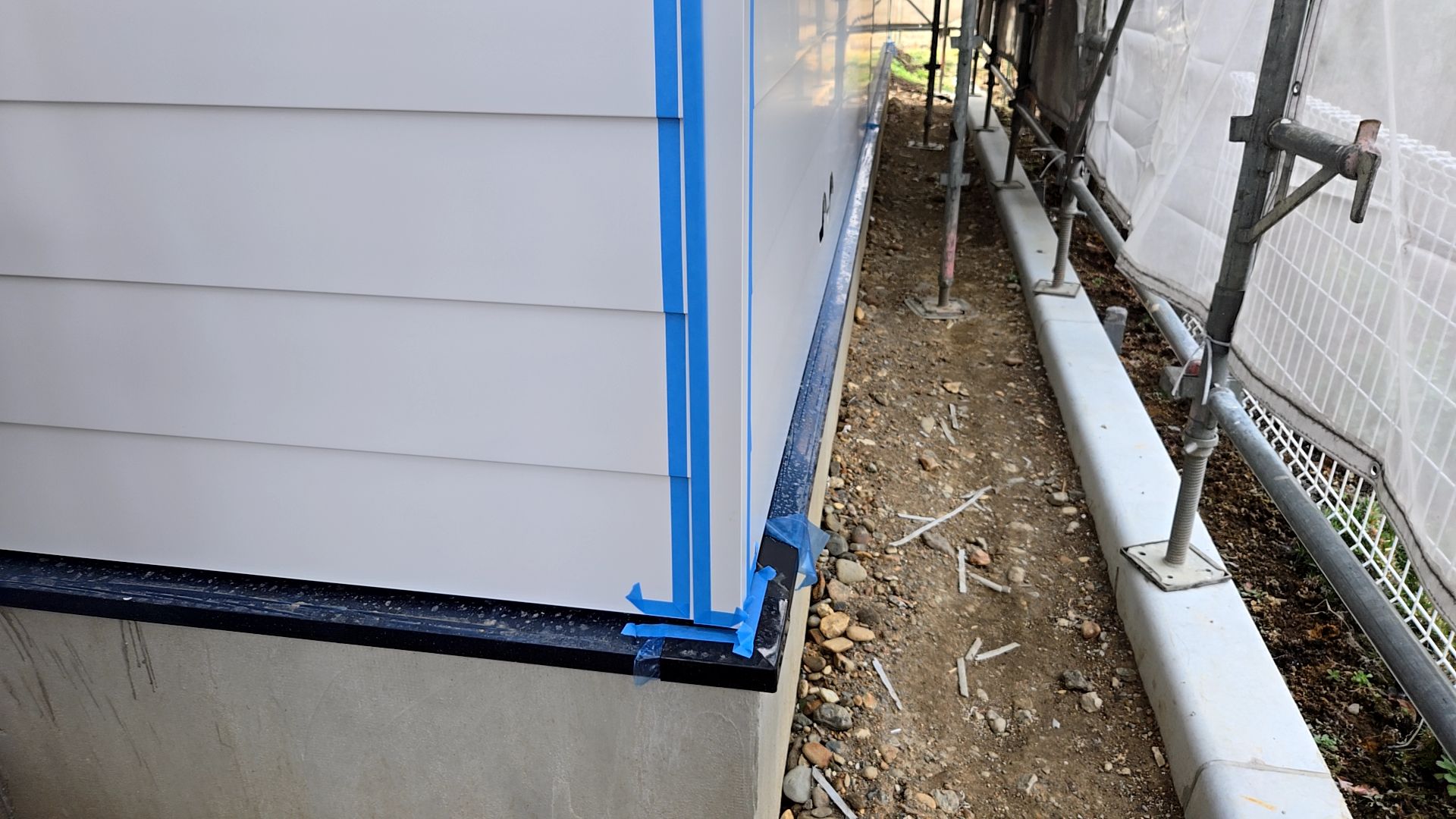 塗装業者による外壁のコーキングが行われている様子です。汚れが付かないようマスキングテープで養生し施工を進めていきます。